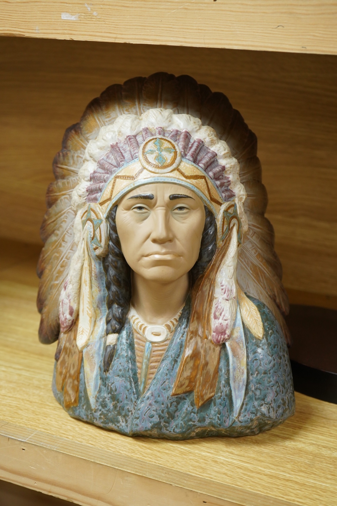 A Lladro bust of a native America chief with feather tribal headdress, 29cm high. (Bust on stand)